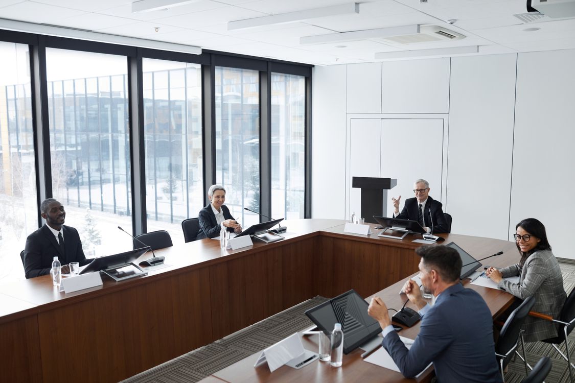 Healthcare leaders meeting in a bright executive boardroom