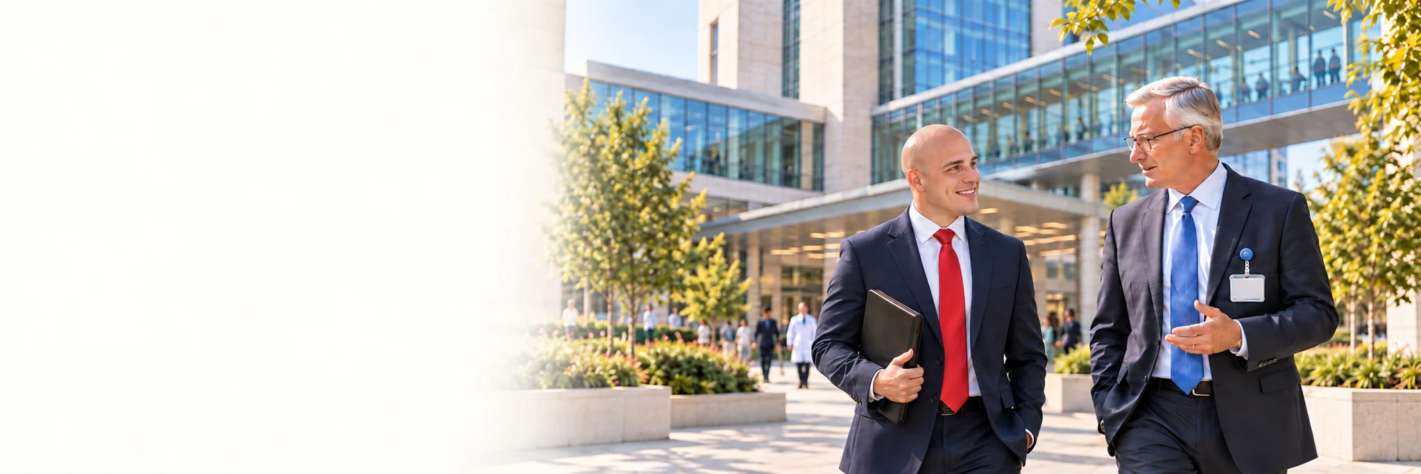 An administrative fellow and a senior executive walking together outside a hospital