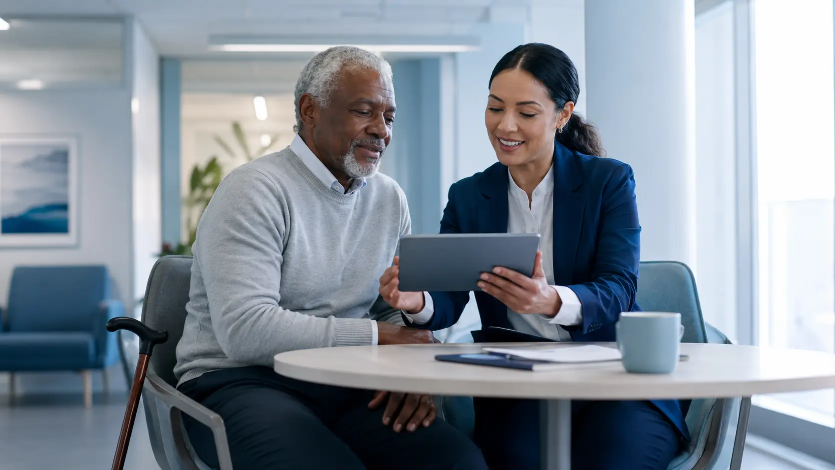 Older adult and care navigator reviewing an accessible care plan together in a bright clinic.