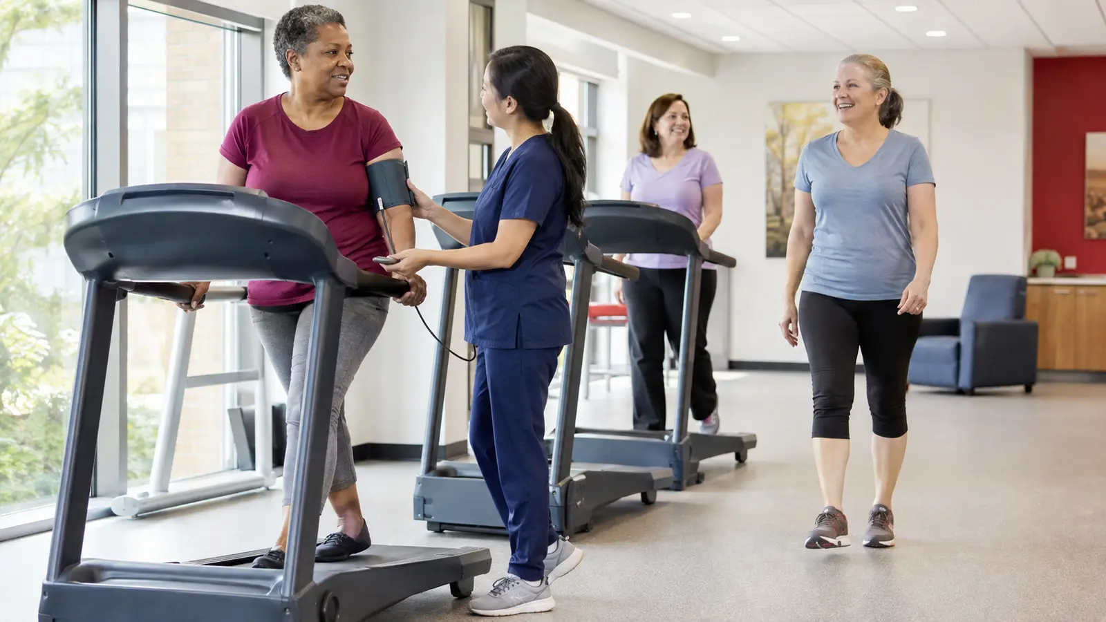A multidisciplinary cardiovascular team and community representative map a connected prevention-to-recovery pathway on a glass wall.