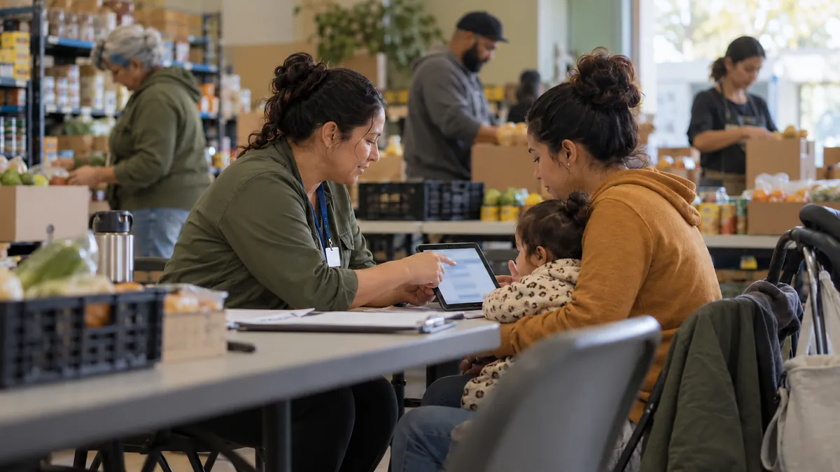 The community health worker helps a young mother sign up for benefits at a neighborhood food pantry.