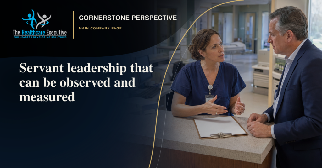 A senior healthcare leader listens closely to a nurse at a hospital workstation, representing observable servant leadership.
