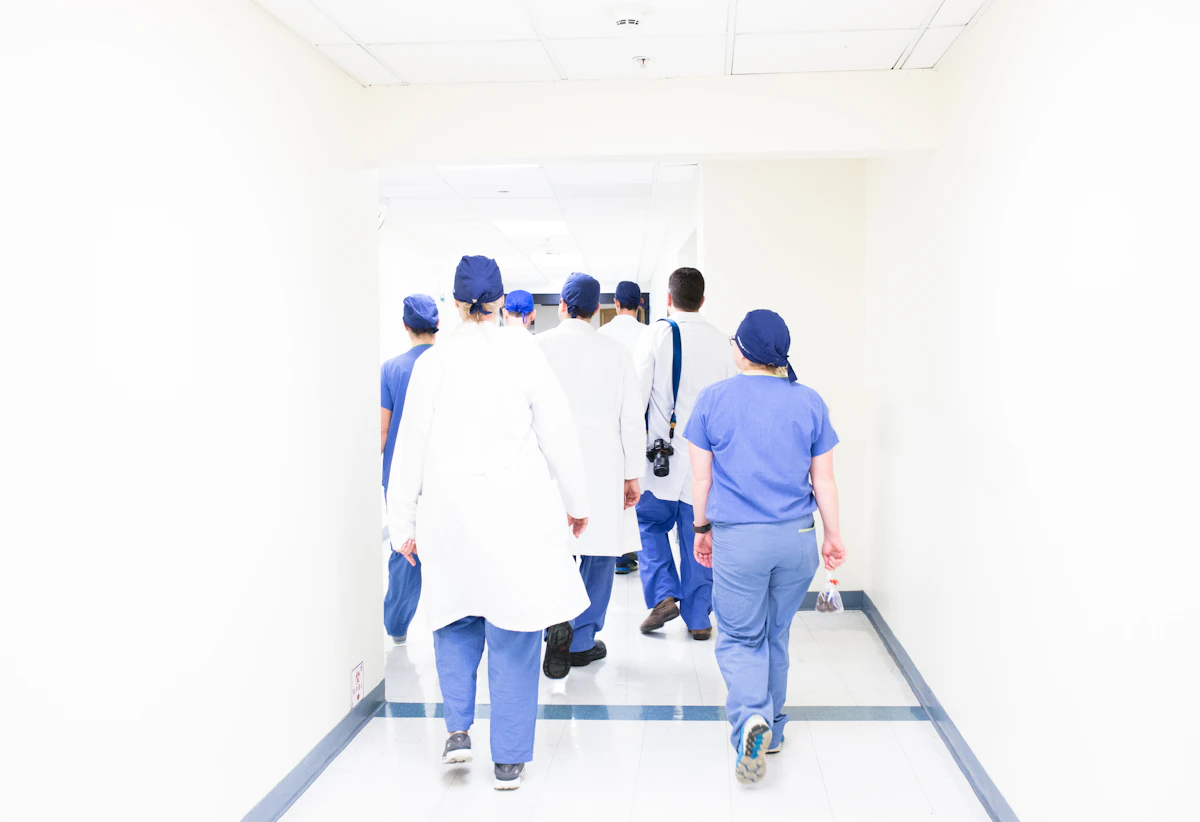 A clinical team walks together through a bright hospital corridor.